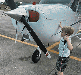 Emerson explores the propeller on the airplane during an NFB BELL field trip.