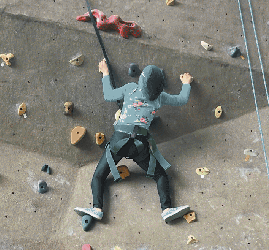 Narjis climbs a rock wall.